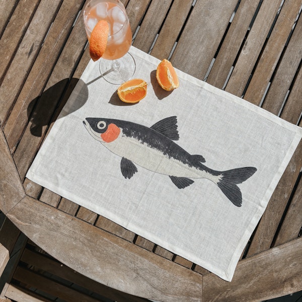 Fish placemat on an outdoor table with drinks