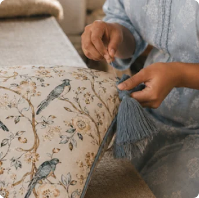 Maker sewing a tassel onto a textile product