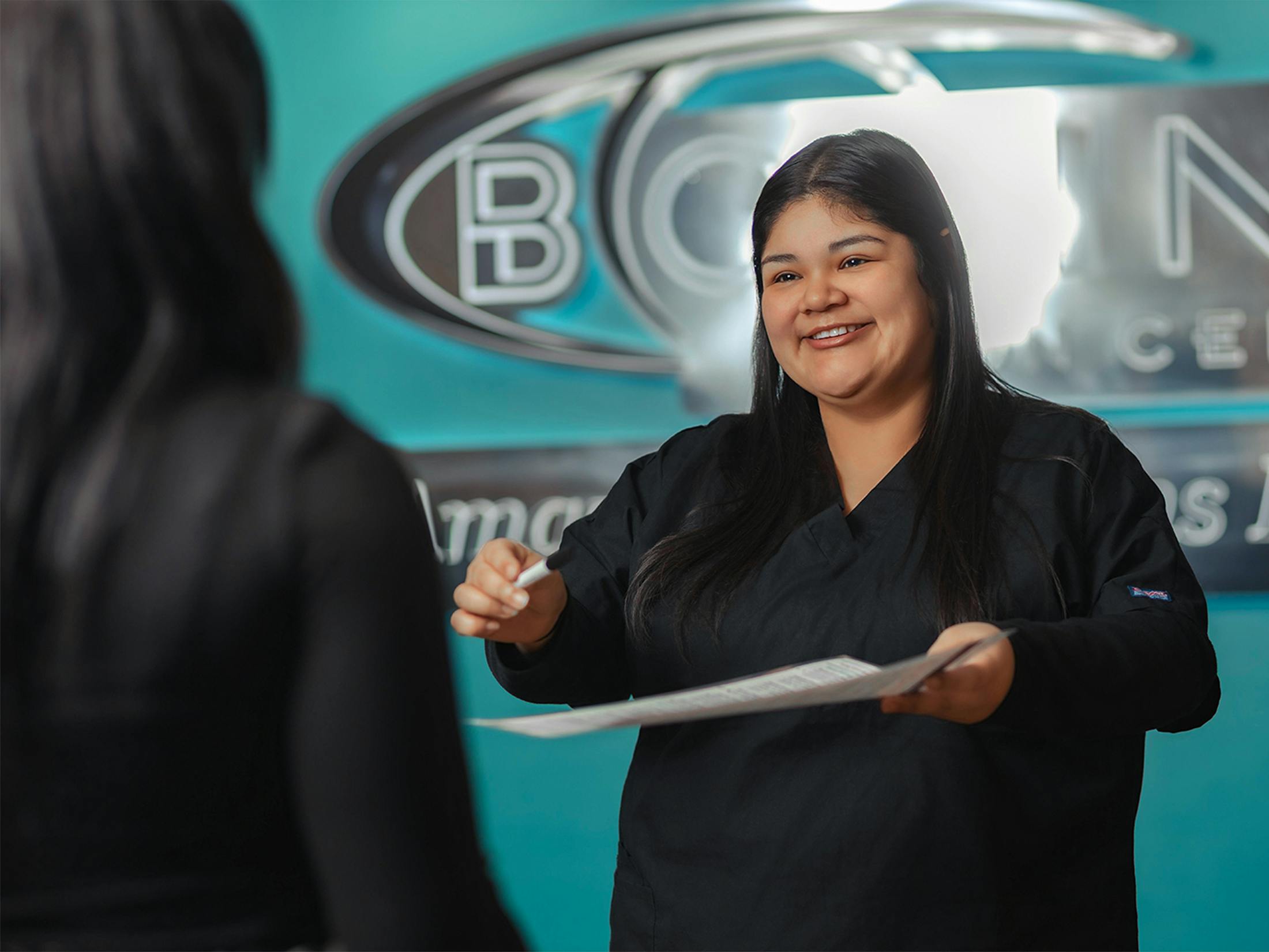 woman handing a patient a paper and pen