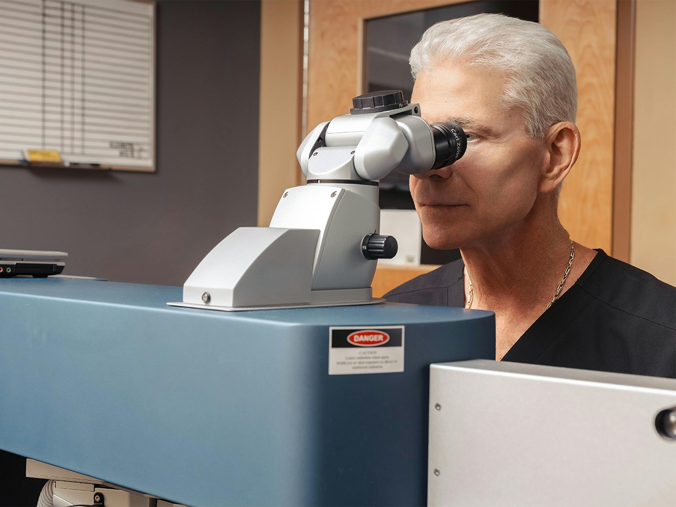 Doctor looking into eye equipment