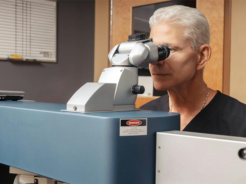 Doctor looking into eye equipment