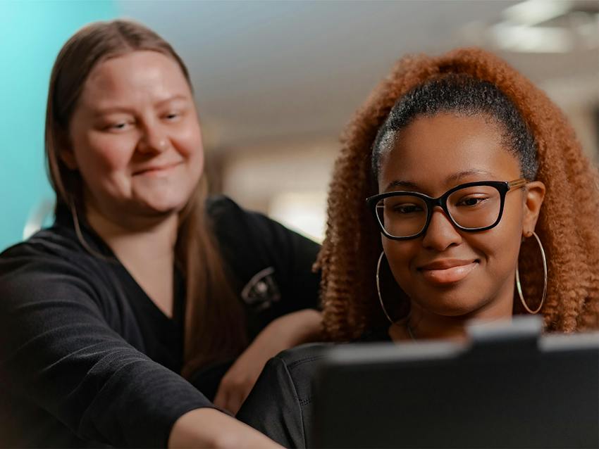 two women looking at a tablet
