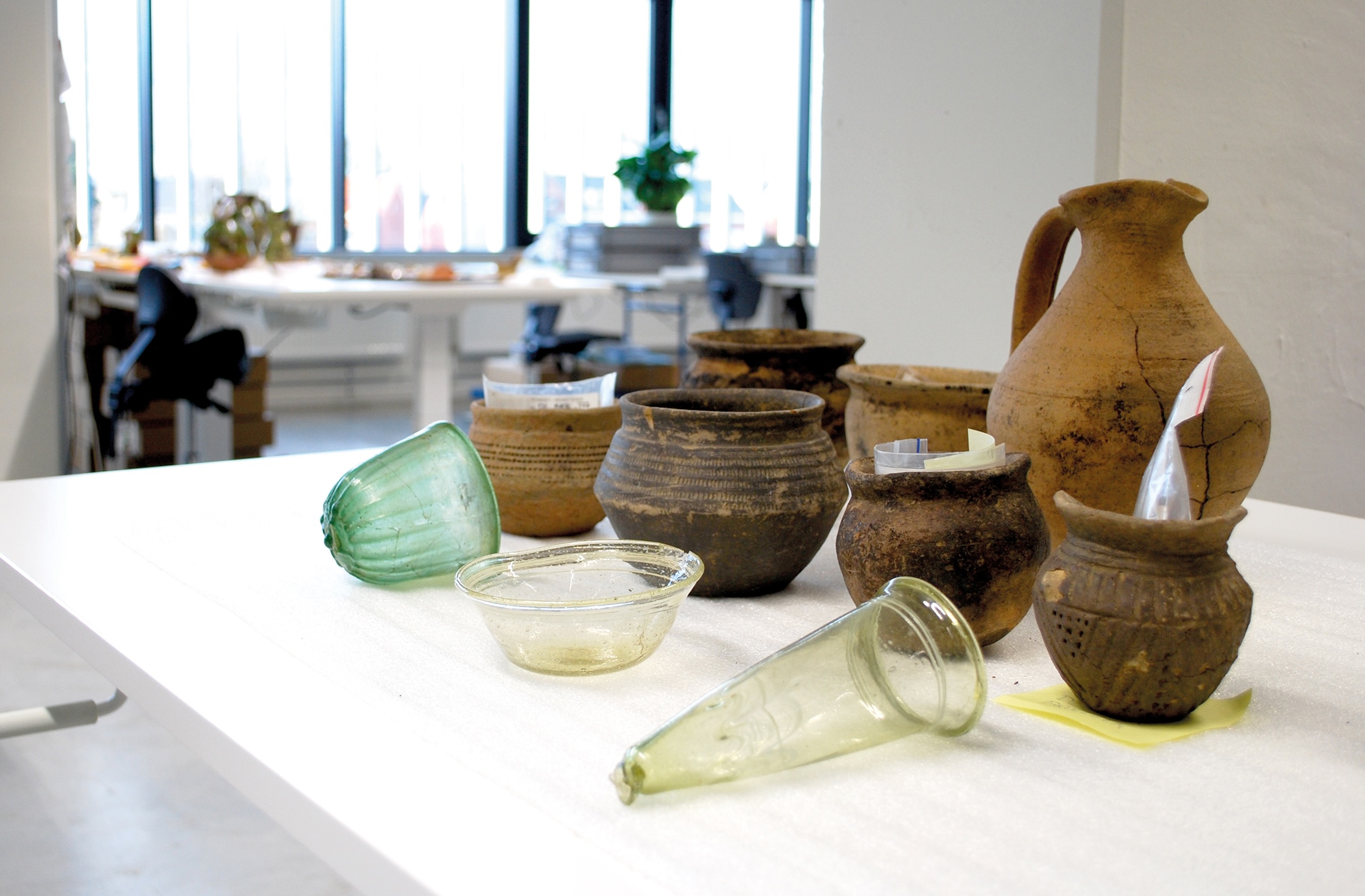 Beeld: Glas- en aardewerk uit de Merovingische tijd, uit opgravingen in Vlaanderen. (Credit: Marco Goole).