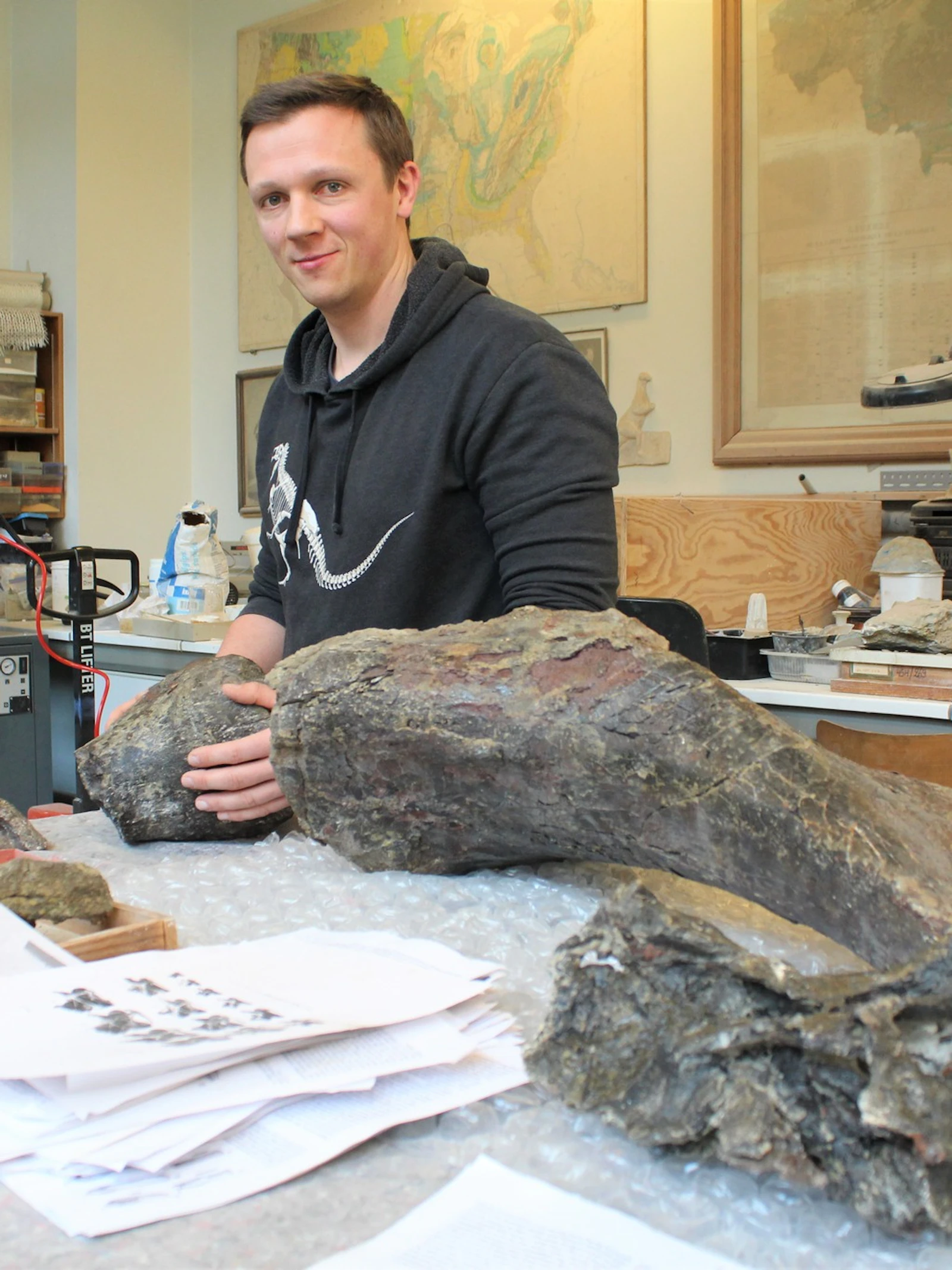 Paleontoloog Koen Stein bij de fossiele botten van Diplodocus Dan