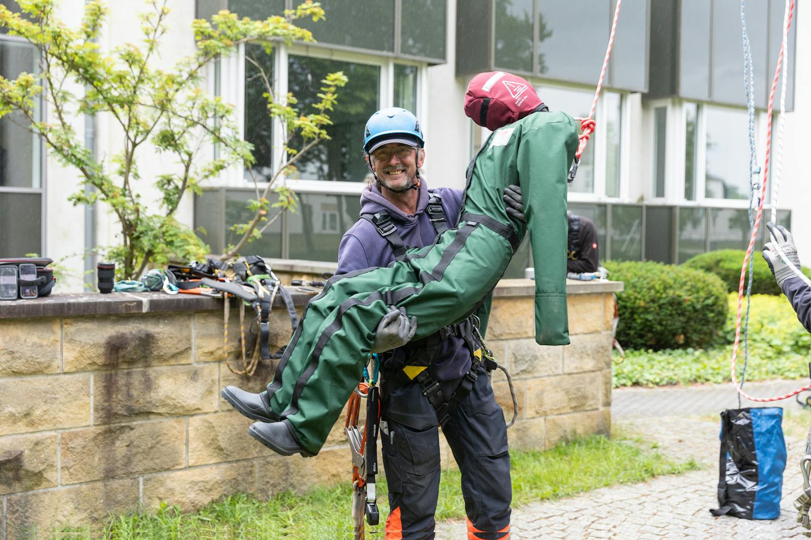 Mitarbeiter von WT Energiesysteme bei einer Schulung zur Arbeitssicherheit und Höhenrettung. Er übt die Rettung einer verunglückten Person mithilfe einer Übungspuppe und spezieller Sicherungsausrüstung.