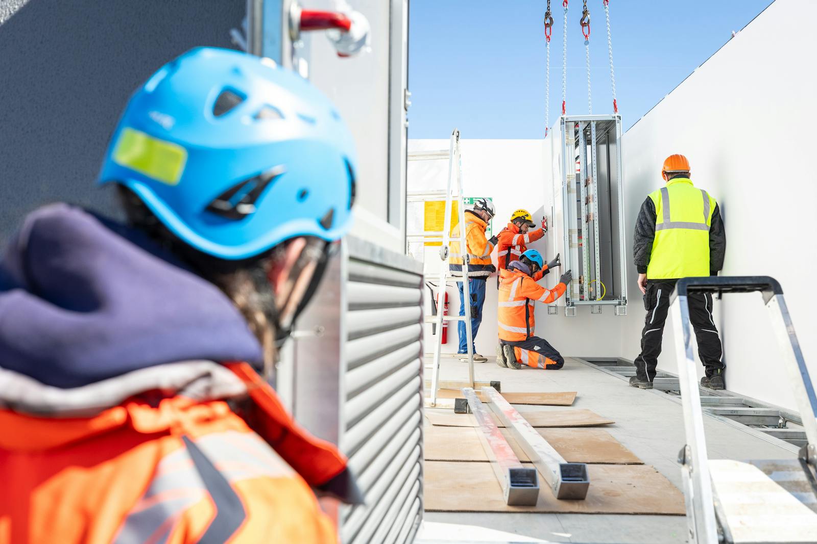 Mitarbeitende von WT Energiesysteme bei der Montage eines Schaltschranks in einem Technikgebäude eines Umspannwerks.
