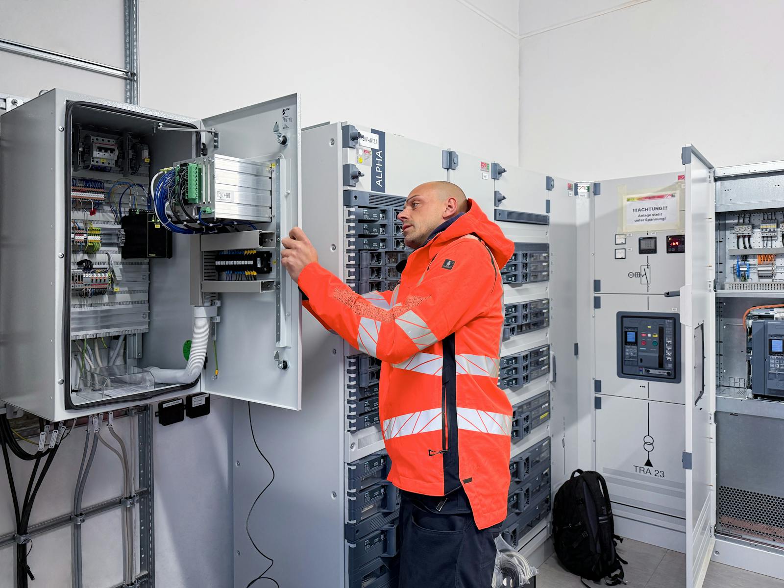 Mitarbeiter von WT Energiesysteme bei der technischen Prüfung eines Schaltschranks für die Schutz- und Leittechnik