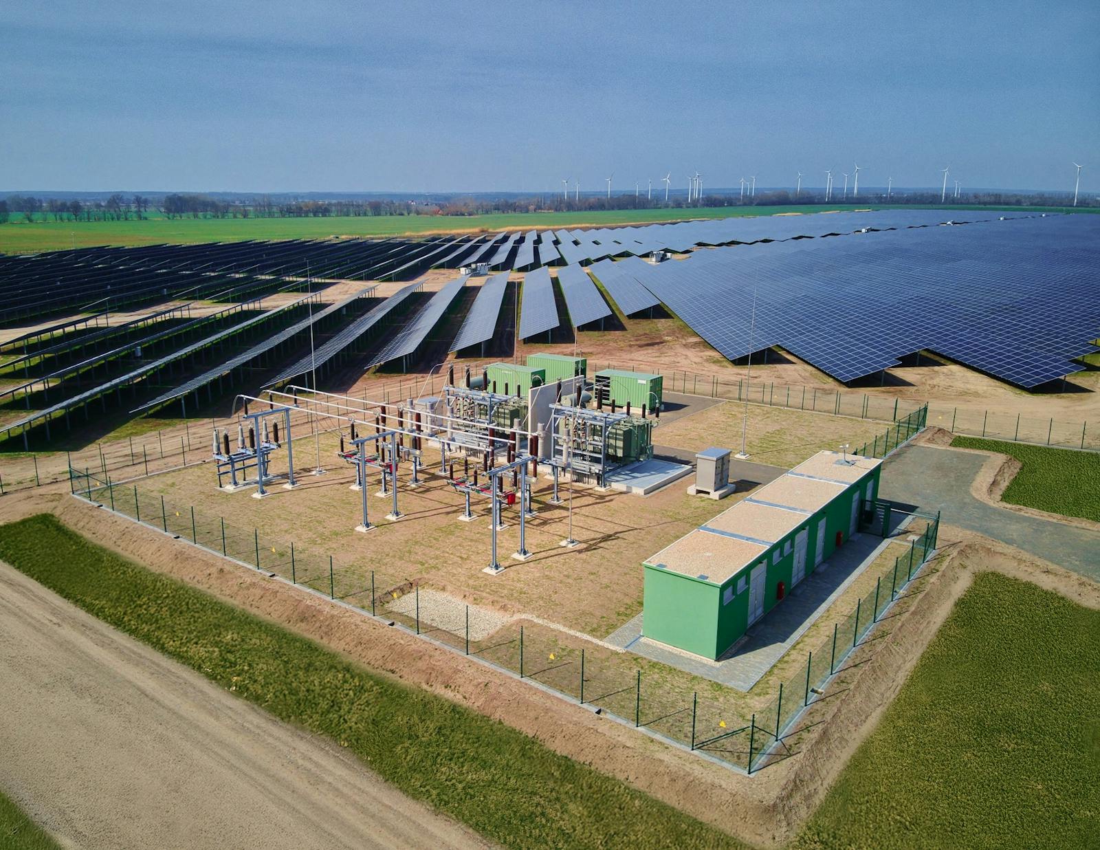 Luftaufnahme eines Umspannwerks mit Leistungstransformator, Hochspannungsschaltanlage und Netzanschlusspunkt zur Einspeisung eines großen Solarparks in das Stromnetz.