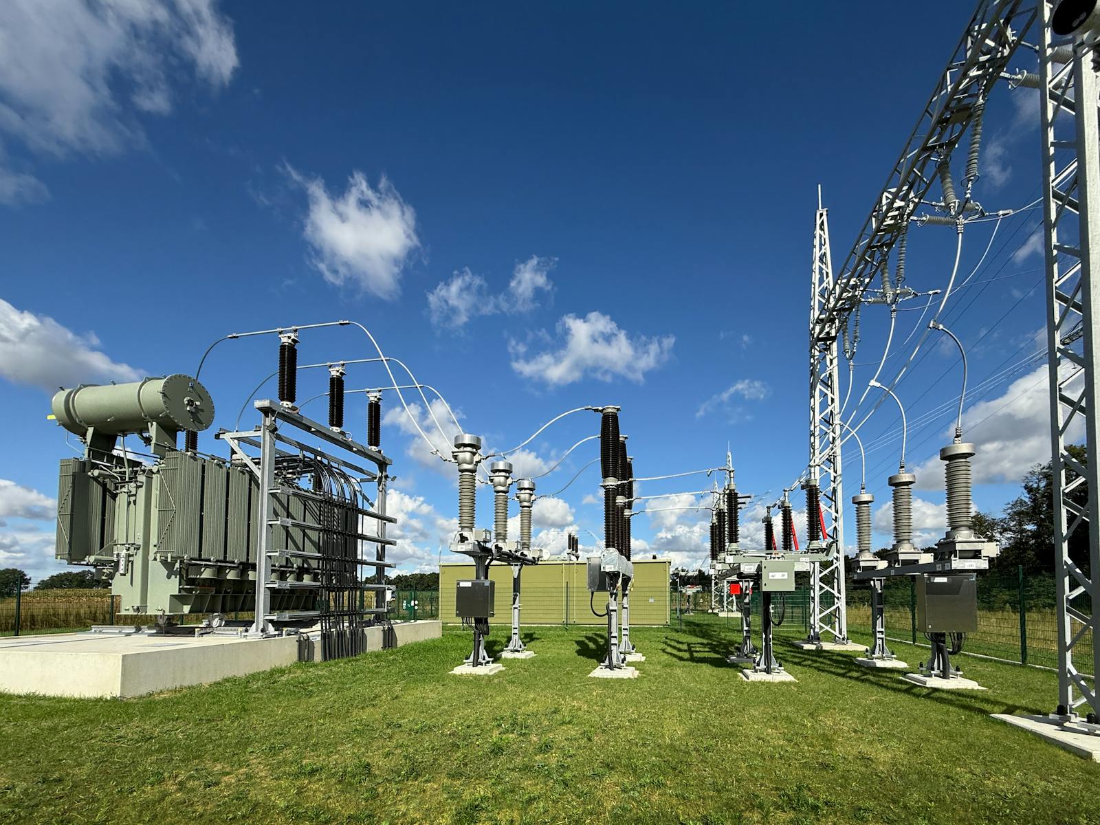 Umspannwerk mit Leistungstransformator, Hochspannungsschaltanlagen, Isolatoren und Stahlgitterportal zur Anbindung an das Stromnetz über Freileitungen.