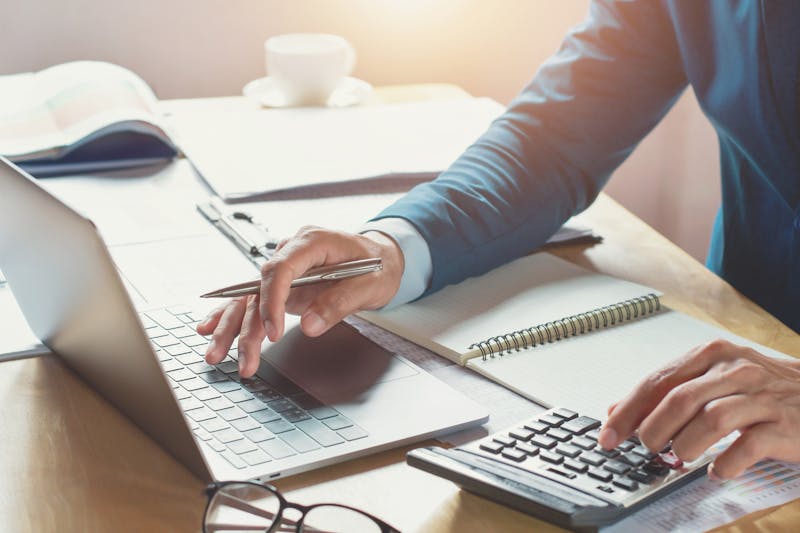 Businessman working in office with using calculator and laptop.