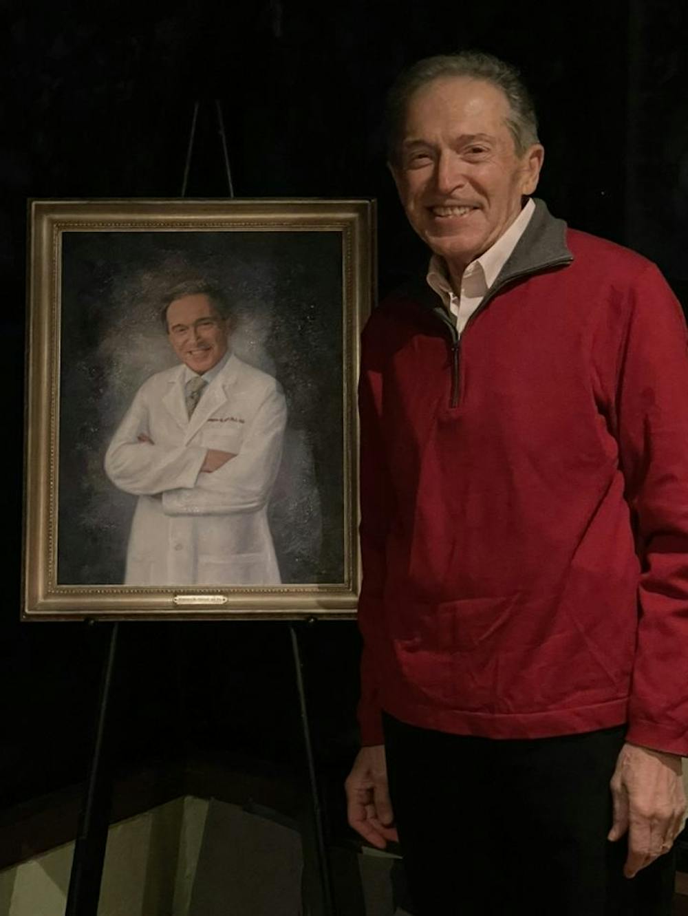 man standing next to his painting