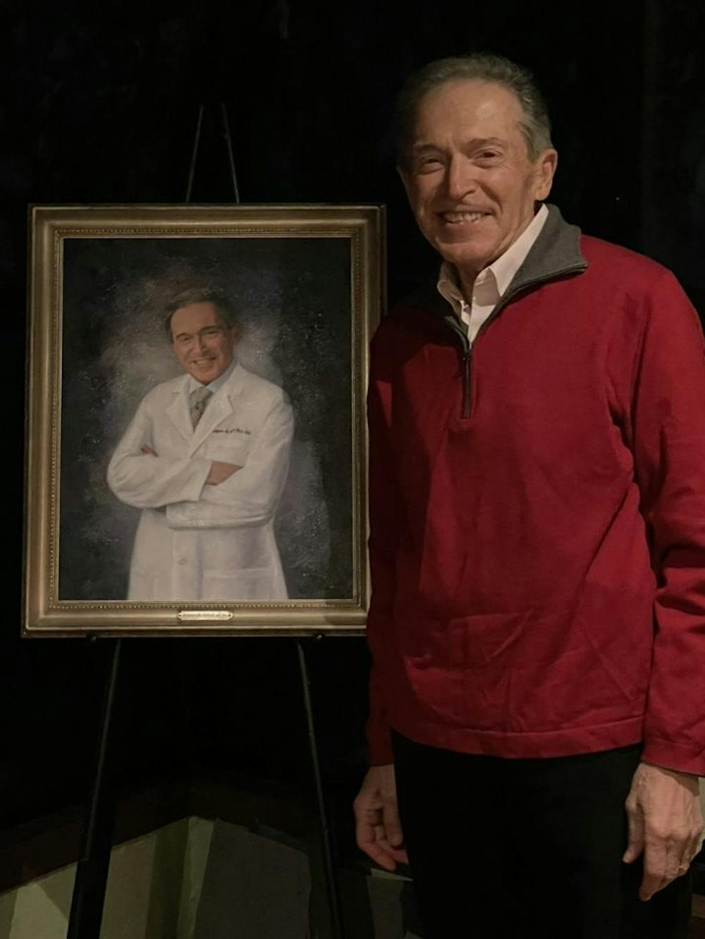 man standing next to his painting