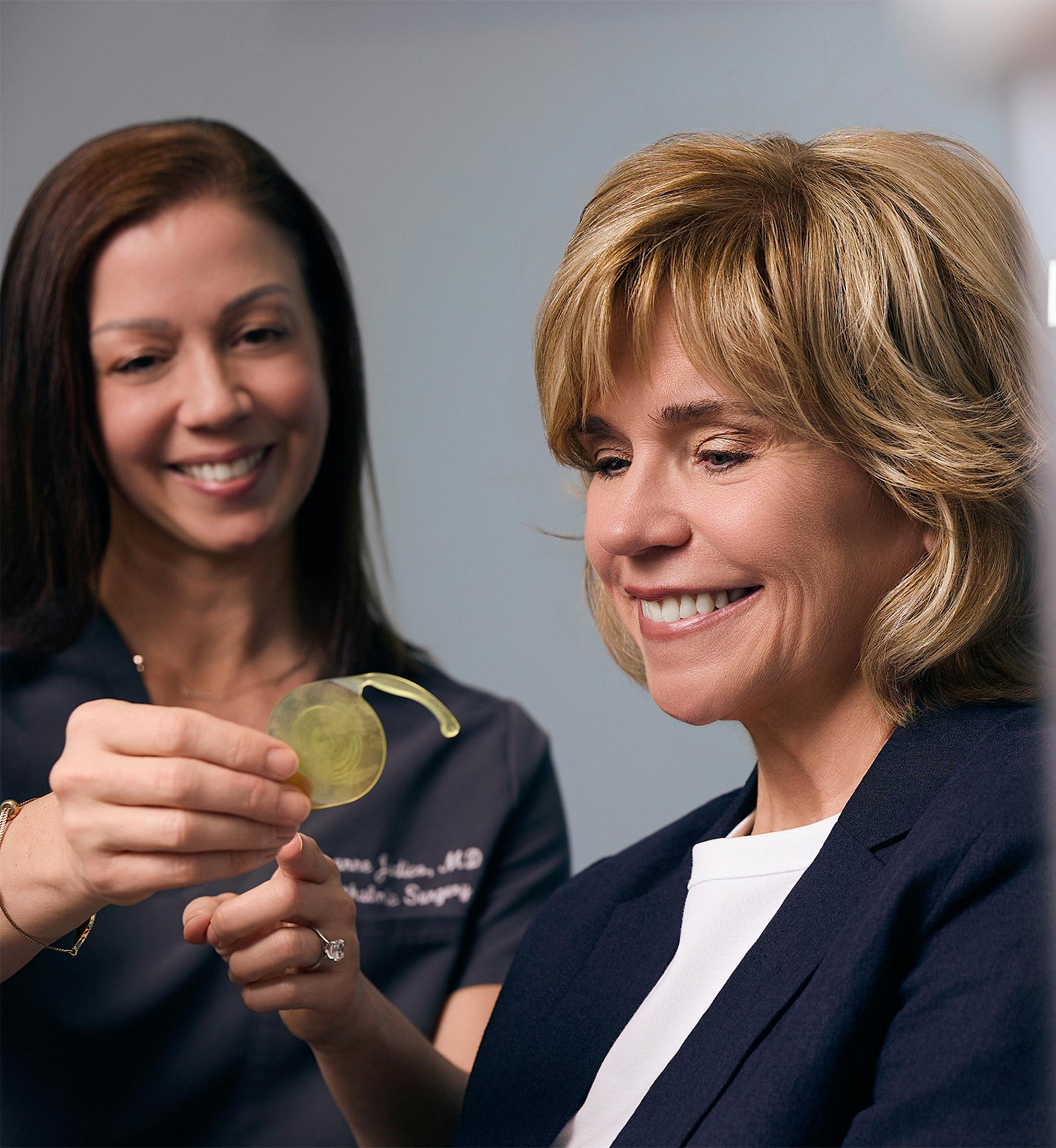 doctor showing a patient a yellow IOL
