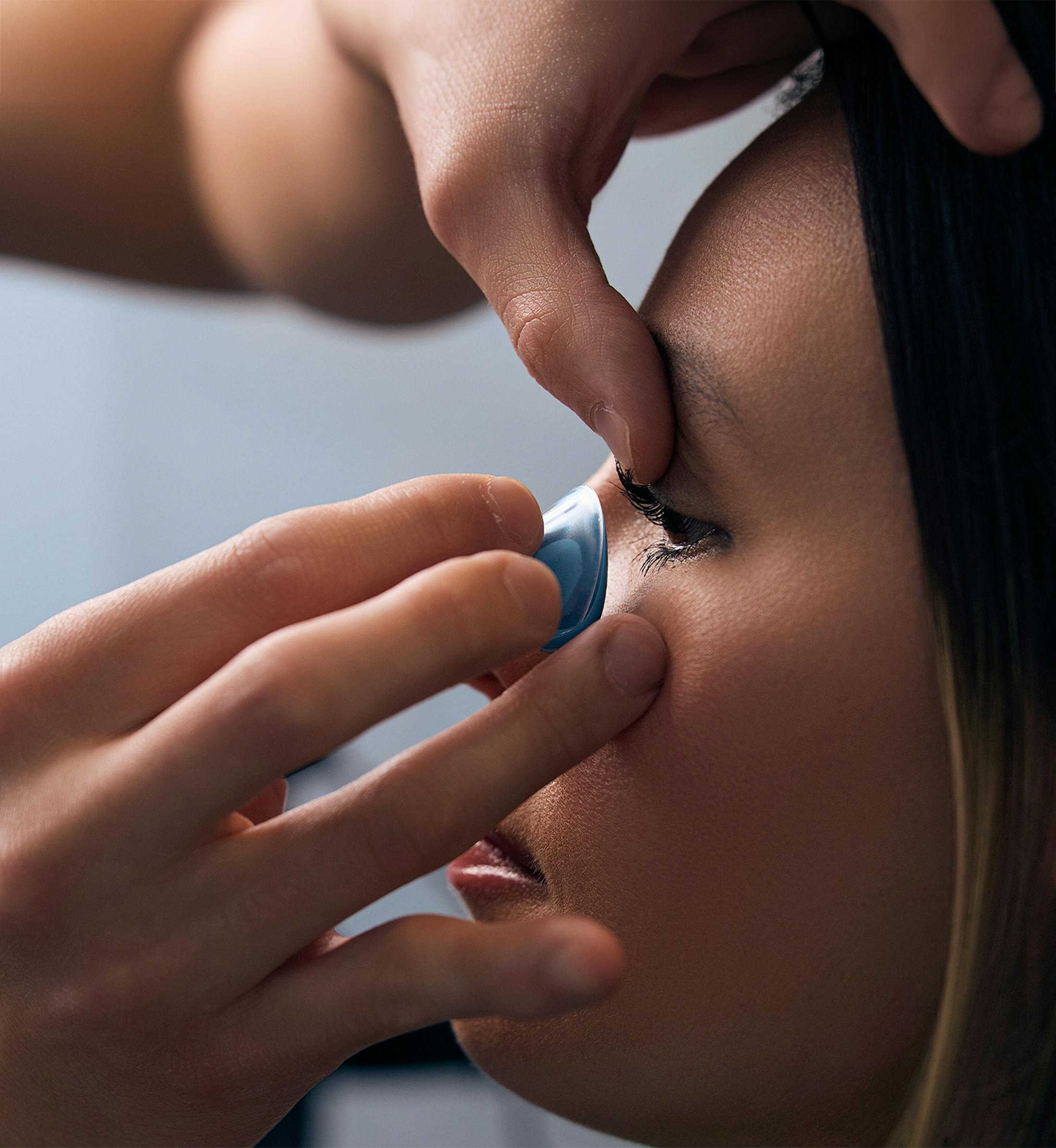 doctor putting a scleral contact lense in a patient's eye