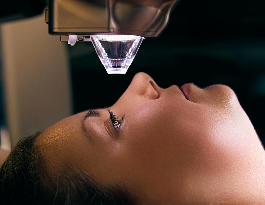 woman sitting under a LASIK machine