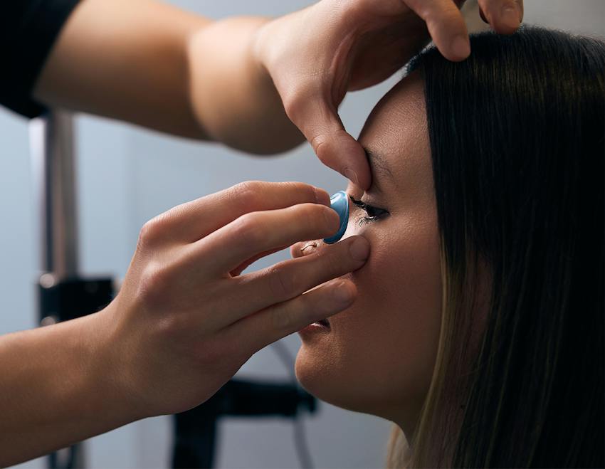 doctor putting a contact into a patient's eye