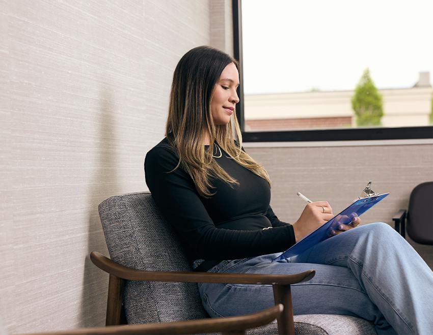 woman writing on a clipboard