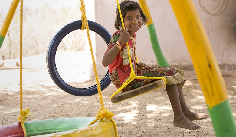 Young girl smiling on swing