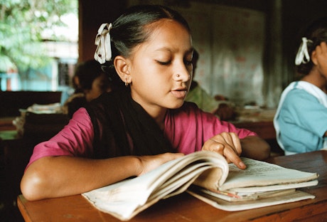 Girl in class reading a book