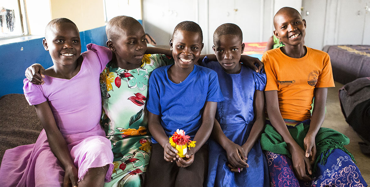 Girls sitting on a bed smiling