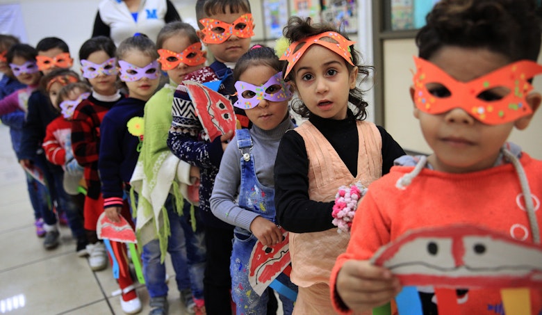 Children standing in line in school, wearing a mask 