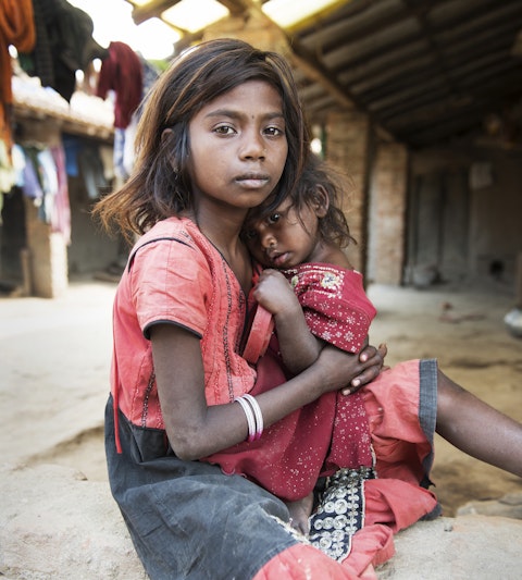 Young girl holding a young child