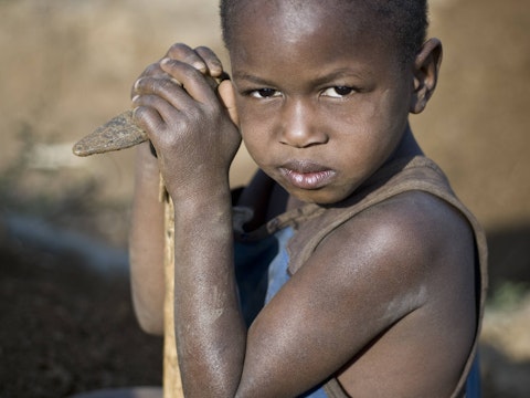 Small child with axe in the gold mines of Tanzania