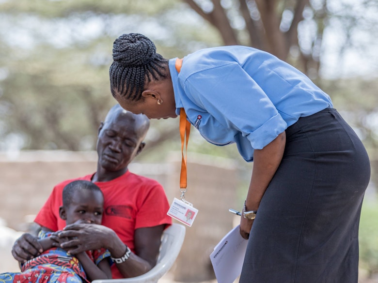 Jesca Edung Lomongin talking to a mother and her child in Turkana, Kenya