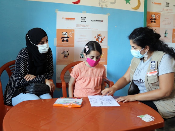 The social worker from Terre des Hommes Italy in Lebanon is explaining to Noor a drawing about diversity. Her mother is also following up. (Project: “Lebanon 2020: Supporting vulnerable boys, girls and caregivers, affected by the Beirut Blast”, Mar Elias Camp in Beirut, May 2021, photography: Terre des Hommes Italy in Lebanon).