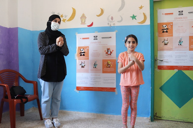 The mother and the daughter are both participating in an activity on COVID-19 precaution techniques. (Project: “Lebanon 2020: Supporting vulnerable boys, girls and caregivers, affected by the Beirut Blast”, Mar Elias Camp in Beirut, May 2021, photography: Terre des Hommes Italy in Lebanon).
