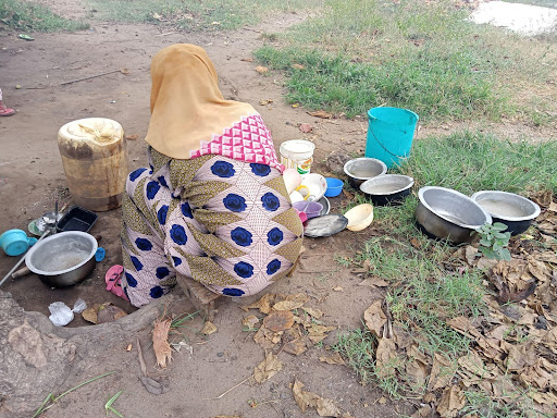 Participant, Jane, washing utensils at home. Photo credit: Kesho Kenya