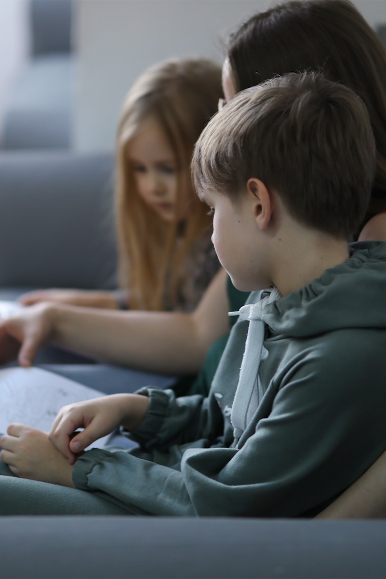 Larysa and her two children Yaroslav and Sophie on the couch in the shelter