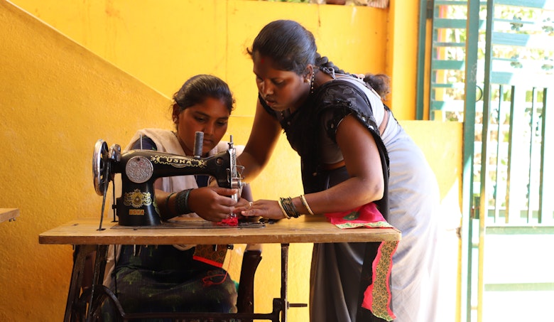 Roopa teaching an early married girl how to sew