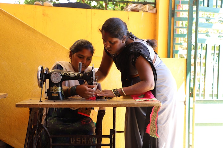Roopa teaching an early married girl how to sew