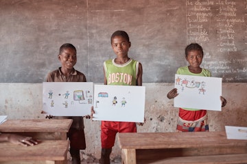 Children holding drawings during the art event in Madagascar