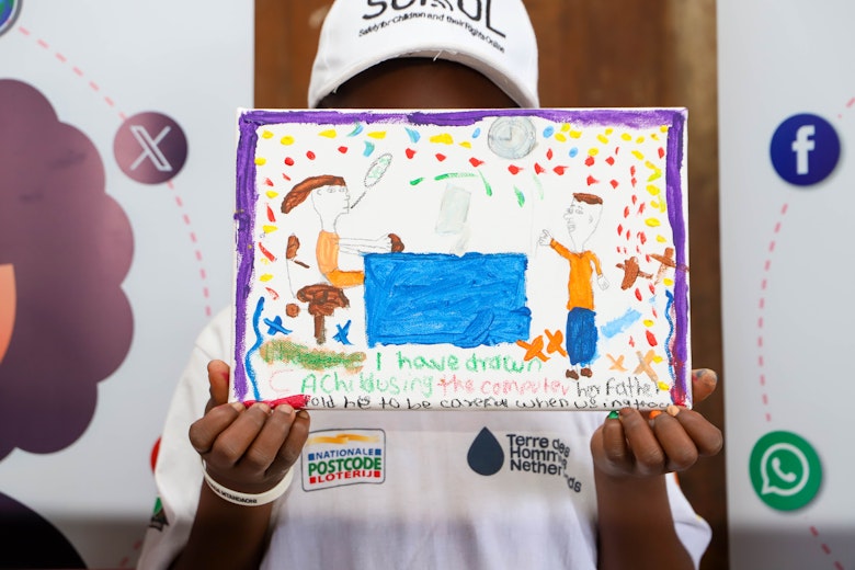 Child holding a drawing during the art event in Kisumu