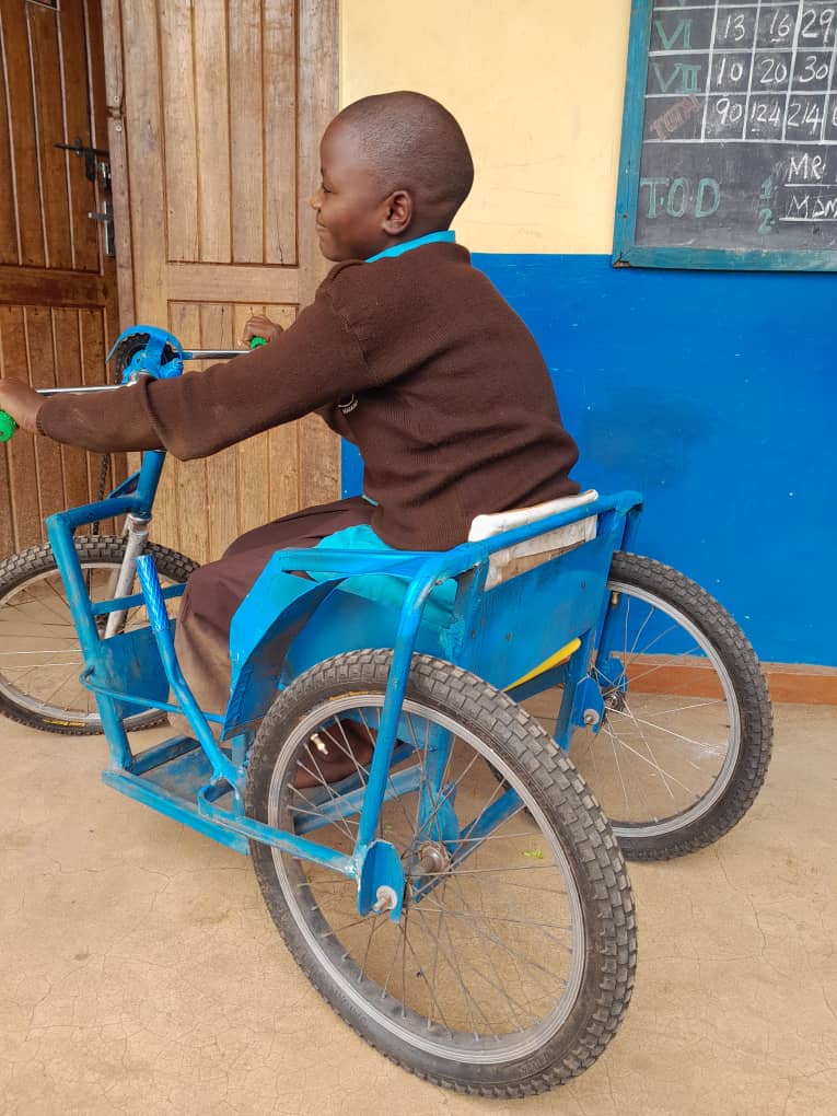 Trisper riding her tricycle in school