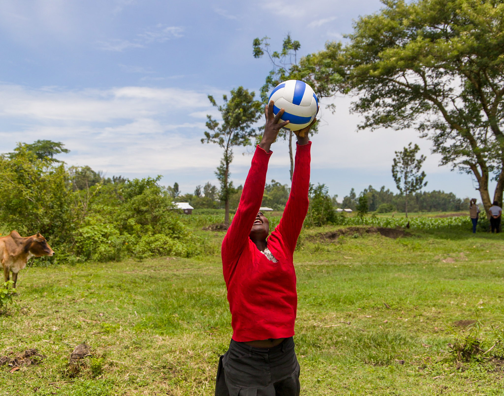 Faith* receiving a volleyball from a friend.