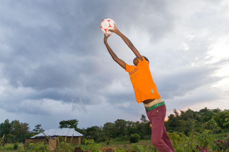 Charang receiving a ball while playing outside with a friend