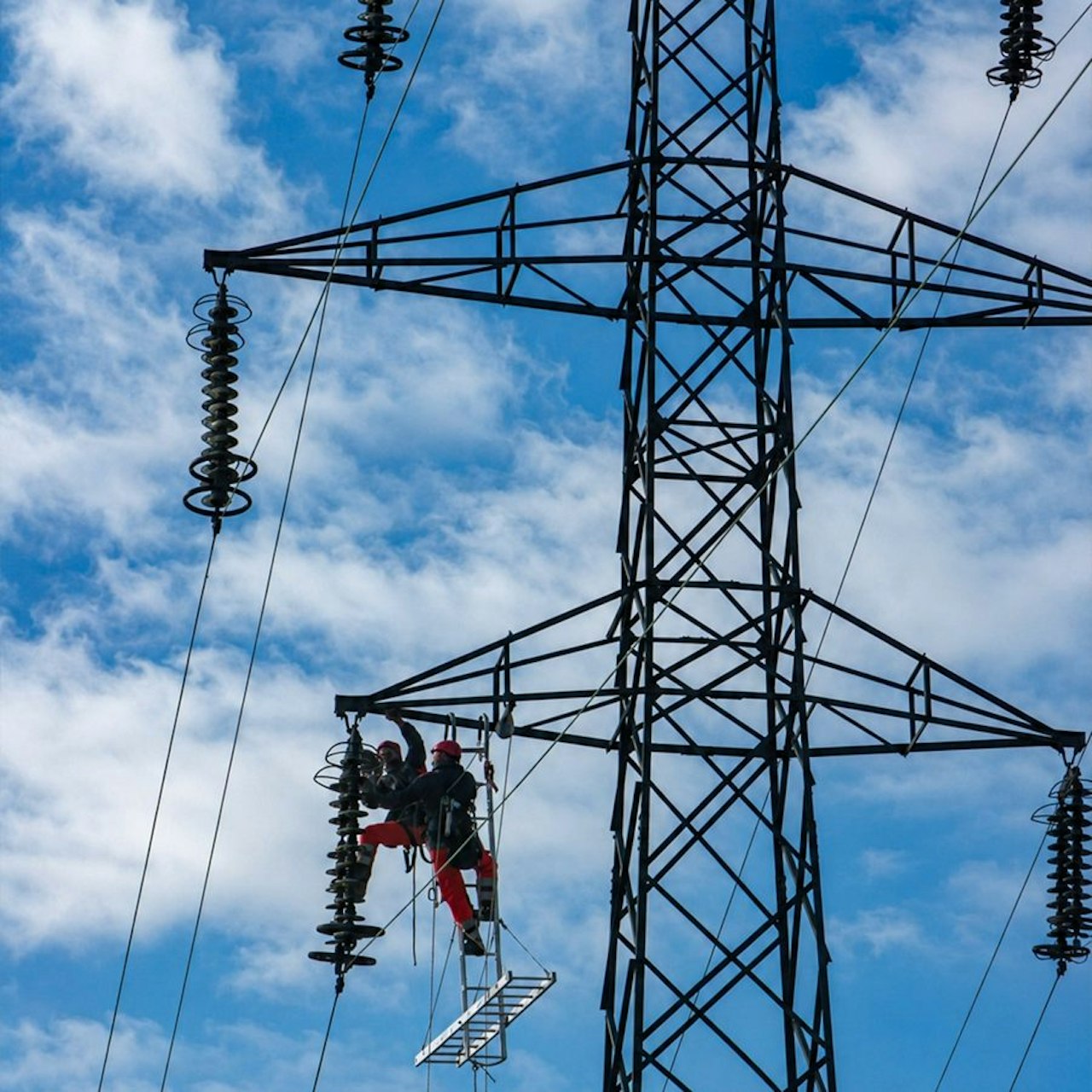 A high-voltage electricity transmission tower against the sky