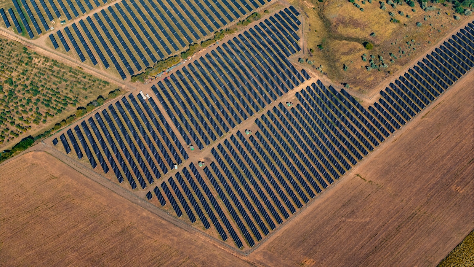 Aerial view of a solar panel array across an open field.