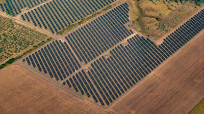 Aerial view of a solar panel array across an open field.