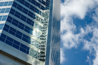 Sunlight and cloud reflected in a glass office tower.