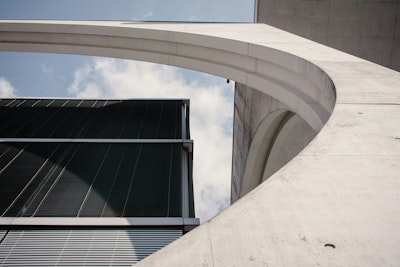 Modern office building facade combining curved concrete and glass.