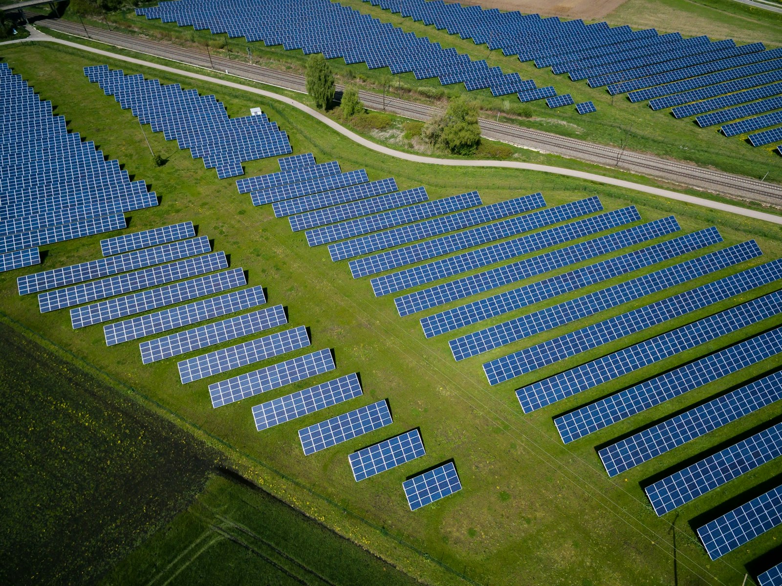 Aerial photography of grass field with blue solar panels.