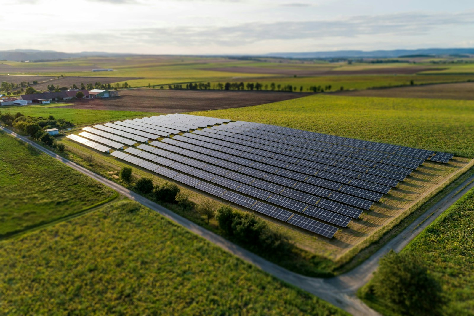 Black solar panels on green grass field during daytime.