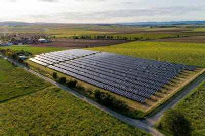 Black solar panels on green grass field during daytime.
