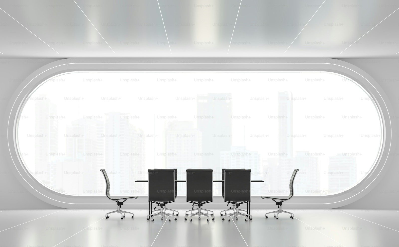 A long conference table with black chairs in a bright modern office.