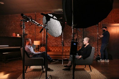 A man and a woman sitting in chairs in front of a camera.