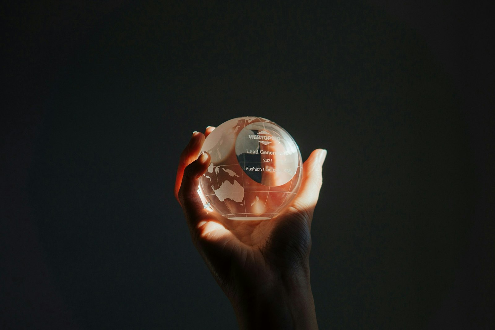 A person holding a glass globe in their hand.